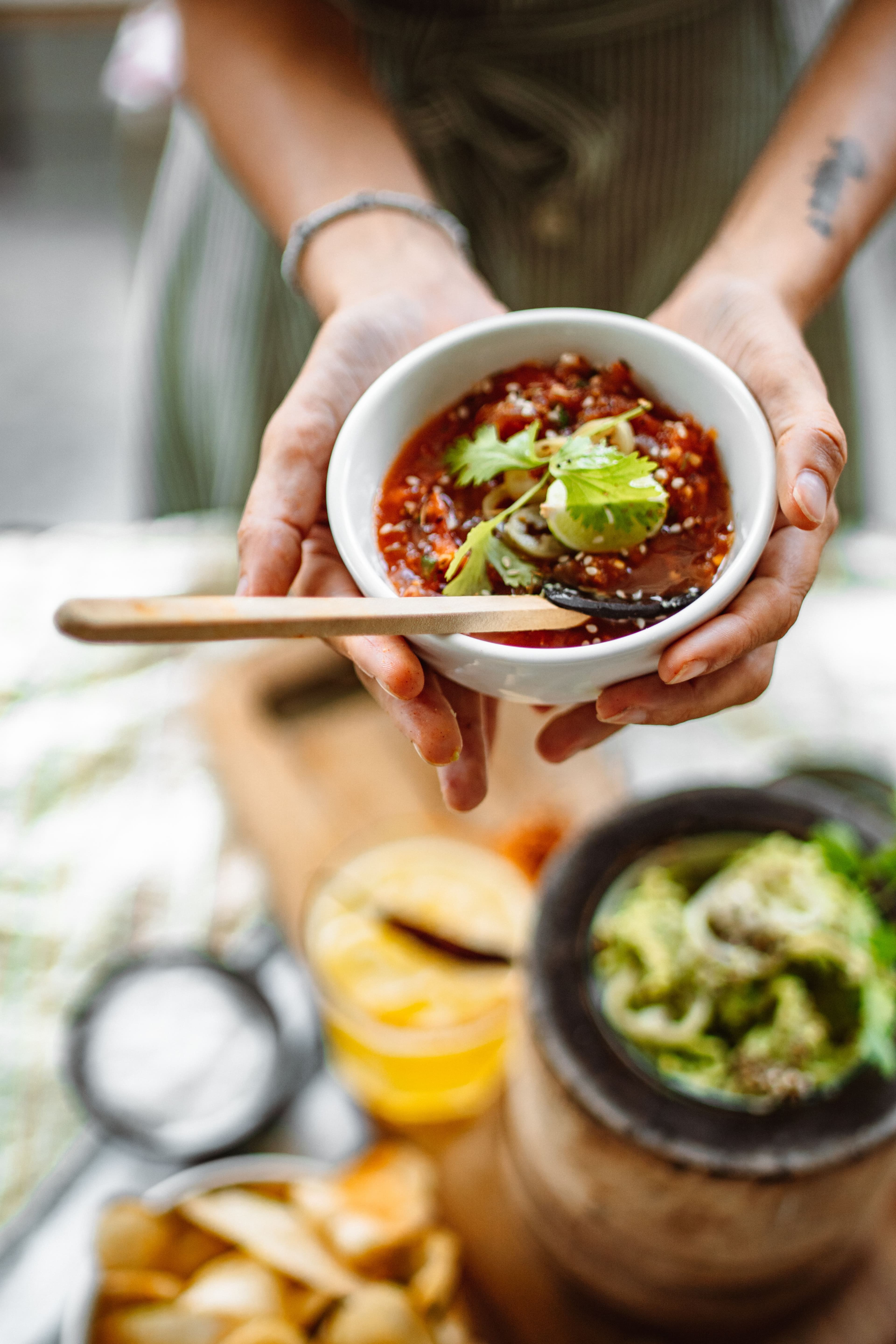 Four bowls of red, green, orange and dark salsa