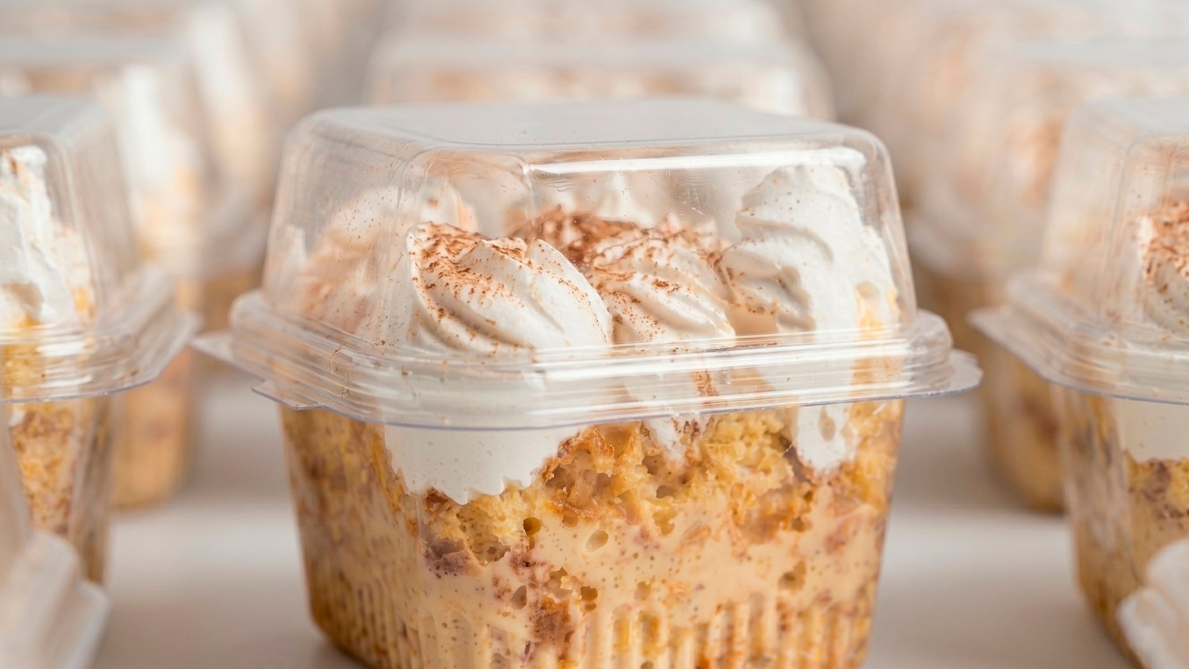 A slice of tres leches cake with a strawberry on a white plate